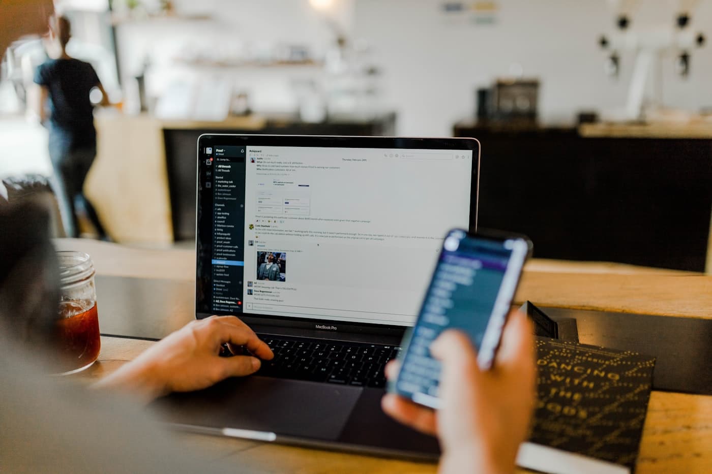 A support agent working across a laptop and a phone